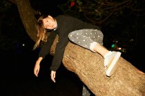 Mulher deitada no galho da árvore grande — Fotografia de Stock