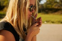 Chica rubia fumando - foto de stock