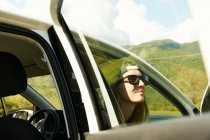 Mulher de óculos de sol sentado no carro — Fotografia de Stock