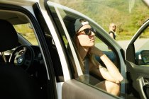Mulher de óculos de sol sentado no carro — Fotografia de Stock