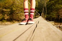 Gambe femminili in calzini e scarpe da ginnastica rosse — Foto stock