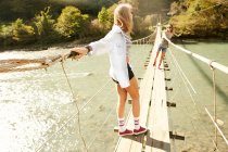 Жінки ходять на висячому пішохідному мосту — стокове фото