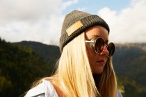 Femme blonde en chapeau et lunettes de soleil — Photo de stock