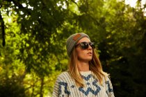 Frau mit Hut und Pullover im Wald — Stockfoto