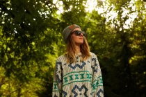 Donna in cappello e maglione nella foresta — Foto stock