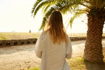 Femme posant sur la plage avec palmier — Photo de stock