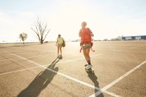 Женщины на скейтборде с рюкзаками — стоковое фото