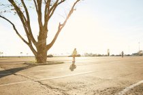 Mulher montando no skate no estacionamento — Fotografia de Stock