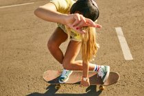 Frau trickst auf Skateboard — Stockfoto