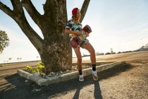 Frau hält Skateboard auf Parkplatz — Stockfoto