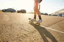 Frau fährt auf Skateboard auf Parkplatz — Stockfoto