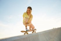 Женщина делает трюк на скейтборде — стоковое фото