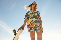 Donna che tiene Skateboard — Foto stock