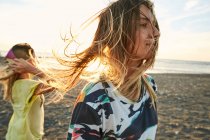 Женщины веселятся вместе на ветреном пляже — стоковое фото