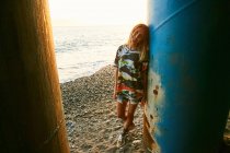 Frau steht neben Säule am Strand — Stockfoto