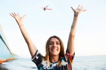 Woman posing with hands up on seaside — Stock Photo