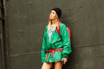Donna in giacca verde con zaino — Foto stock