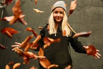 Chica posando con hojas de otoño - foto de stock