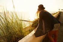 Девушка наблюдает за водой на границе на берегу моря — стоковое фото