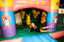 Girl having fun inflatable castle — Stock Photo