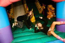Friends having fun inflatable castle — Stock Photo
