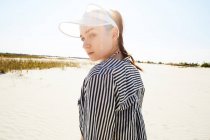 Woman in white visor posing on beach — Stock Photo