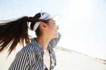 Woman in white visor enjoying sun — Stock Photo