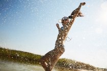 Жінка в козирі біжить у воду — стокове фото