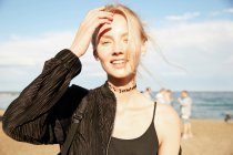 Portrait of smiling woman looking at camera on beach in barcelona — Stock Photo