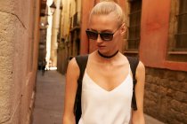 Beautiful woman in sunglasses walking on street in barcelona — Stock Photo