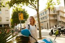 Jovem mulher de pé perto estacionado motos na rua em barcelona — Fotografia de Stock