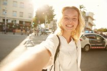 Ponto de vista da câmera de mulher sorridente andando com saco na rua em barcelona — Fotografia de Stock