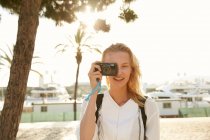 Fröhliche junge touristin fotografiert mit digitalkamera auf der straße in barcelona — Stockfoto