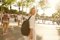 Happy woman walking with bag on street and looking at camera in barcelona — Stock Photo