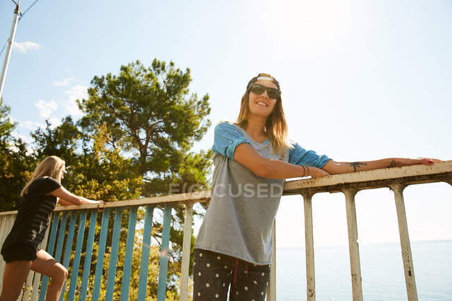 Women standing on seaside bridge — Stock Photo