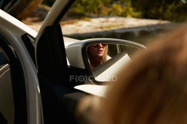 Blonde girl reflection in side mirror — Stock Photo