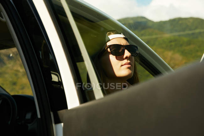 Woman in sunglasses sitting in car — Stock Photo
