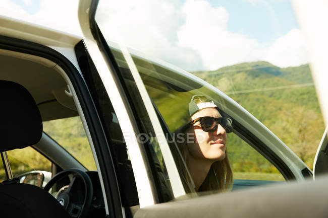 Жінка в сонцезахисних окулярах сидить в машині — стокове фото
