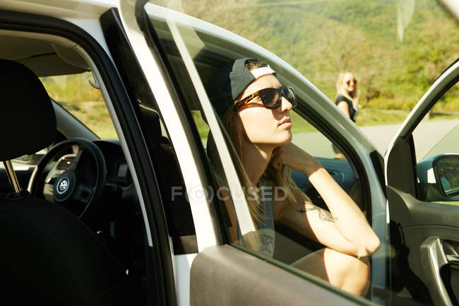 Женщина в солнцезащитных очках сидит в машине — стоковое фото