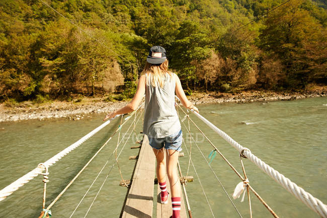 Frau läuft auf Hängebrücke — Stockfoto
