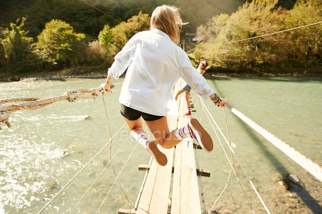 Women walking on hanging footbridge — Stock Photo