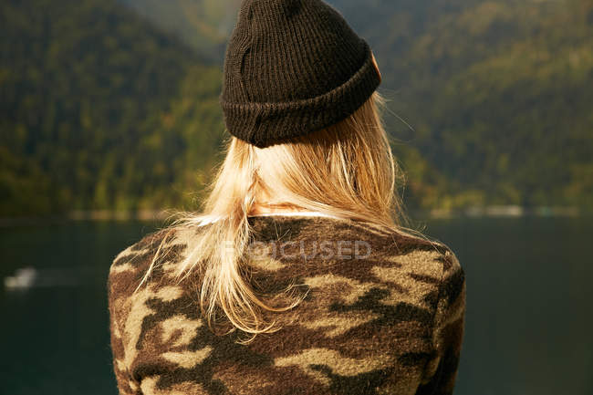 Menina loira de chapéu no fundo da floresta — Fotografia de Stock