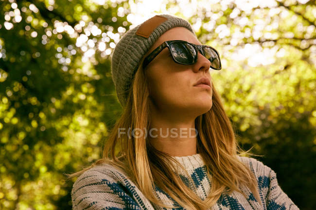 Жінка в капелюсі і светрі в лісі — стокове фото