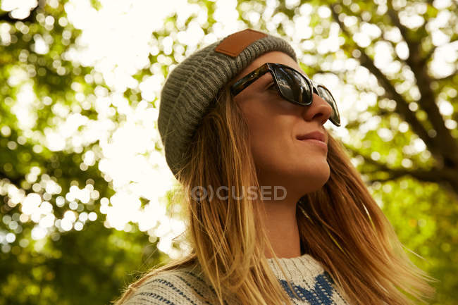 Donna in cappello e maglione nella foresta — Foto stock