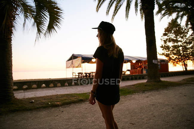 Женщина на берегу моря рядом с пляжным баром — стоковое фото