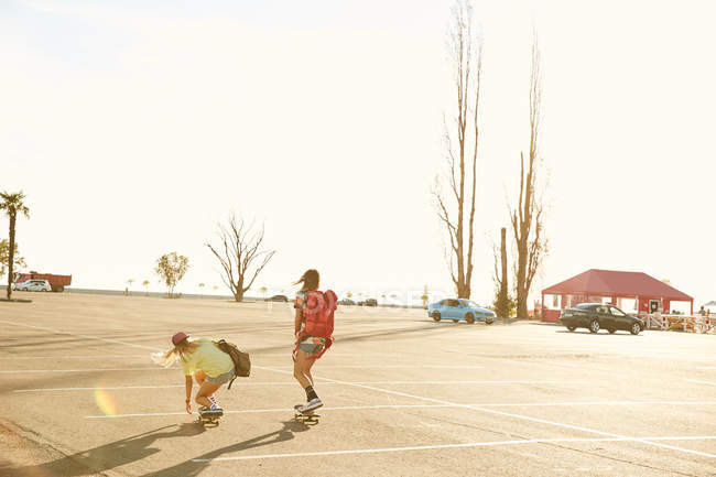Жінки катаються на скейтбордах з рюкзаками — стокове фото