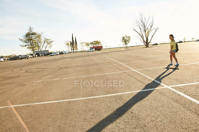 Donna che cavalca sullo skateboard nel parcheggio — Foto stock