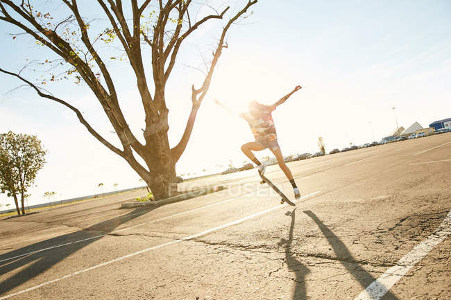 Woman doing trick on skateboard — Stock Photo