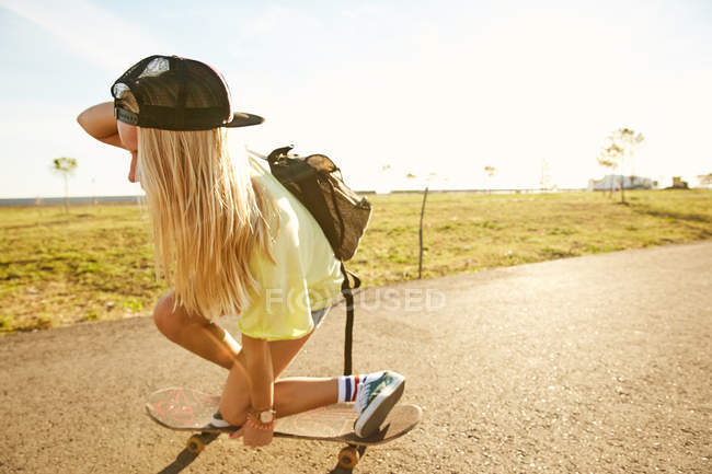 Femme faisant astuce sur skateboard — Photo de stock