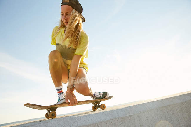 Woman doing trick on skateboard — Stock Photo